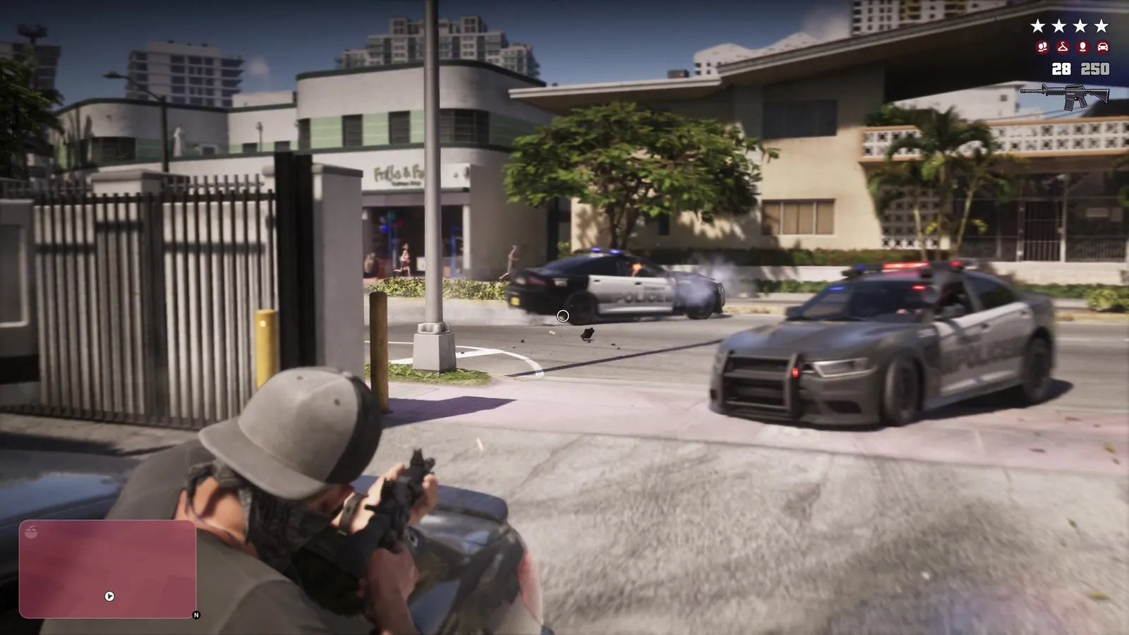 A gray police car with a push bar pulls up toward a gunman crouched behind a car.