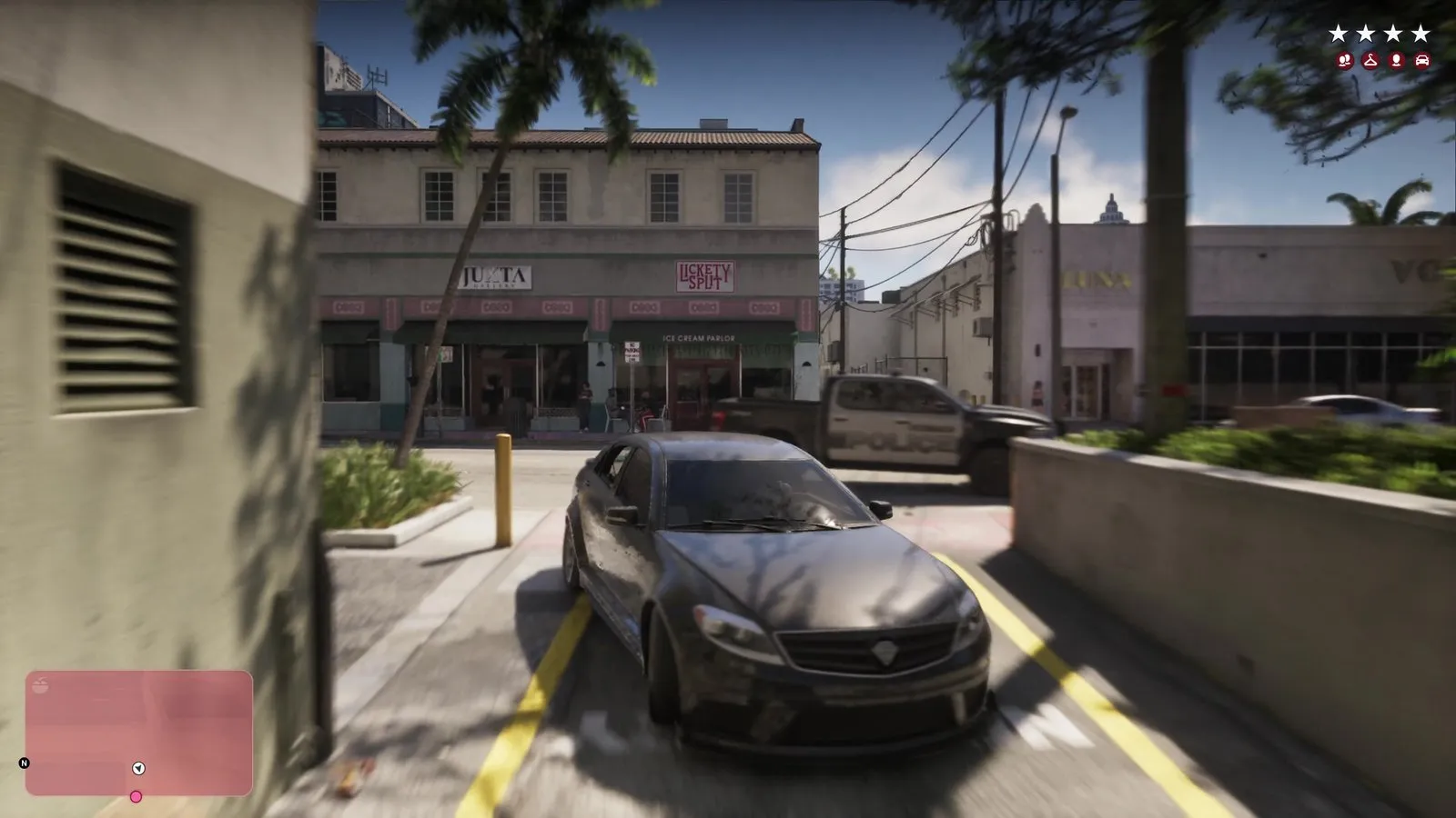 With four wanted stars on screen, a police pickup crosses the street behind a dark sedan pulling out of an alley.