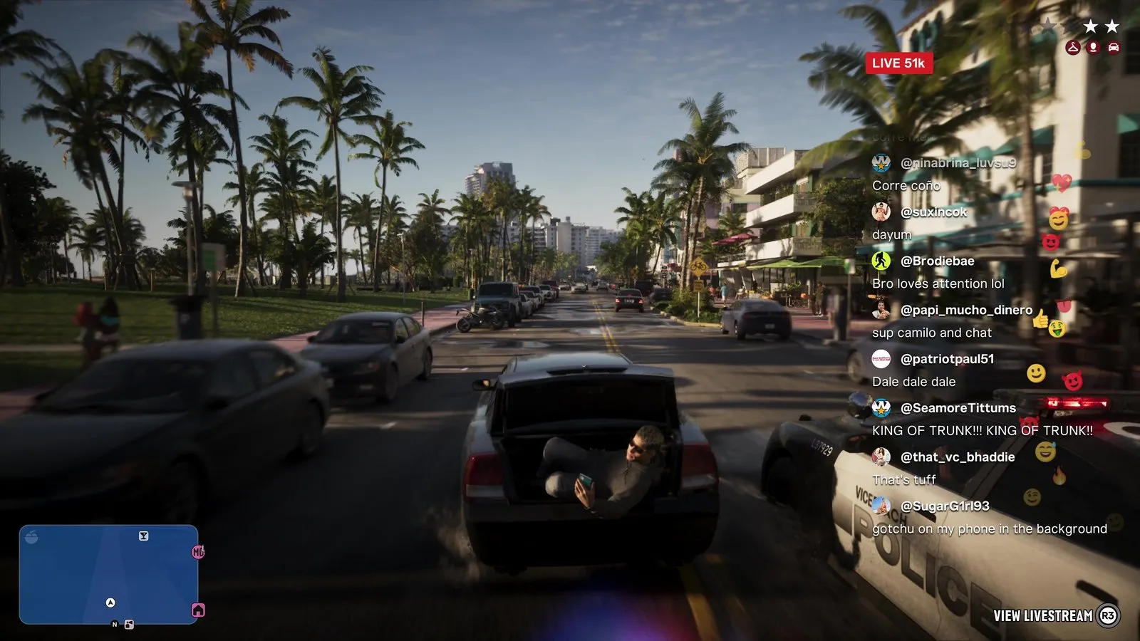 A police car with its light bar lit pulls alongside a dark sedan whose passenger films himself from the open trunk during a chase.