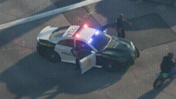 Close-up: two tone: white front end, front doors and roof, dark green rear, gold badge on the front door, black roof lettering