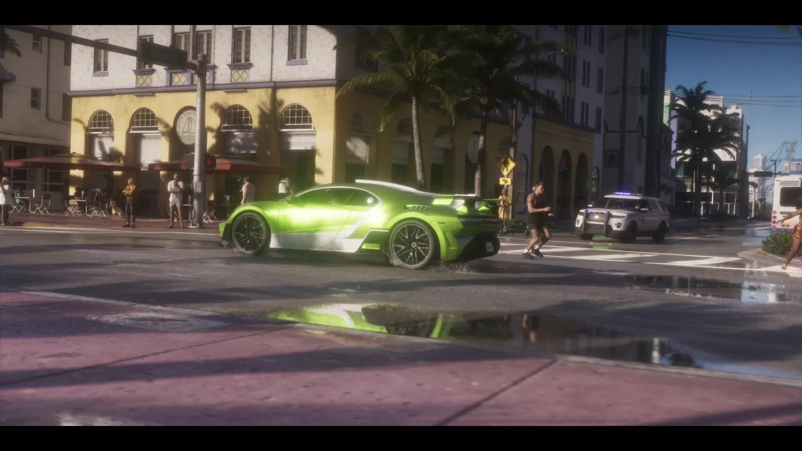A white police SUV with blue lights on enters an intersection as a green supercar skids past pedestrians.