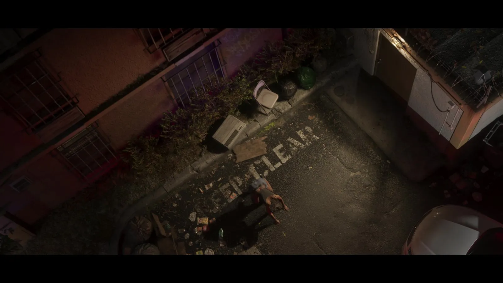 Seen from above, a woman lies on the littered pavement of an alley at night next to a partly visible white car.